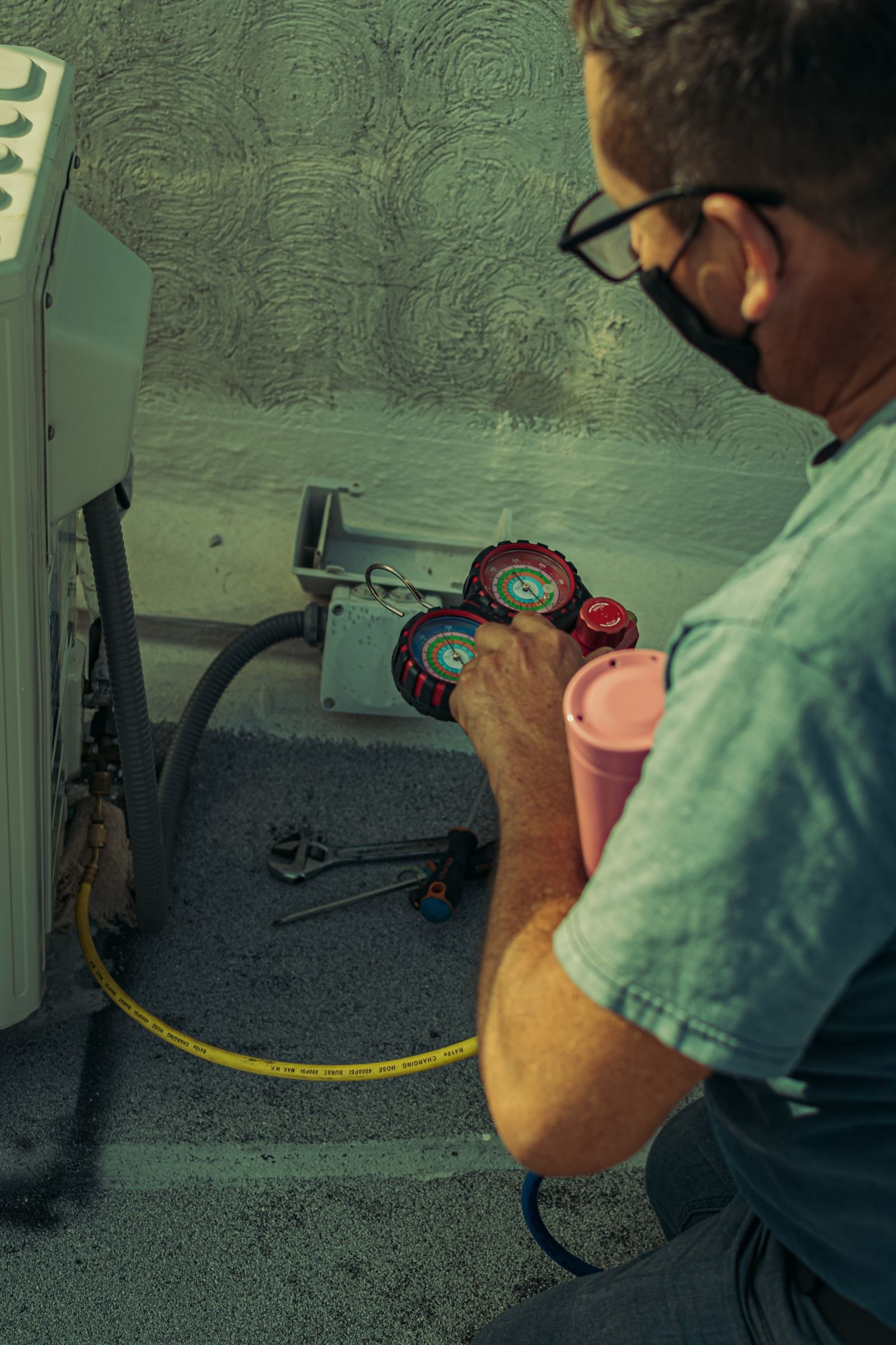 A home-service technician inspecting an outdoor air-conditioning unit.