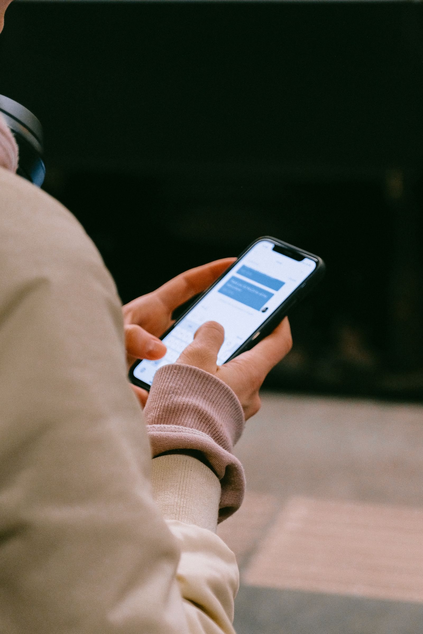 A person scrolls on a smartphone, illustrating competing demands for a customer’s attention.